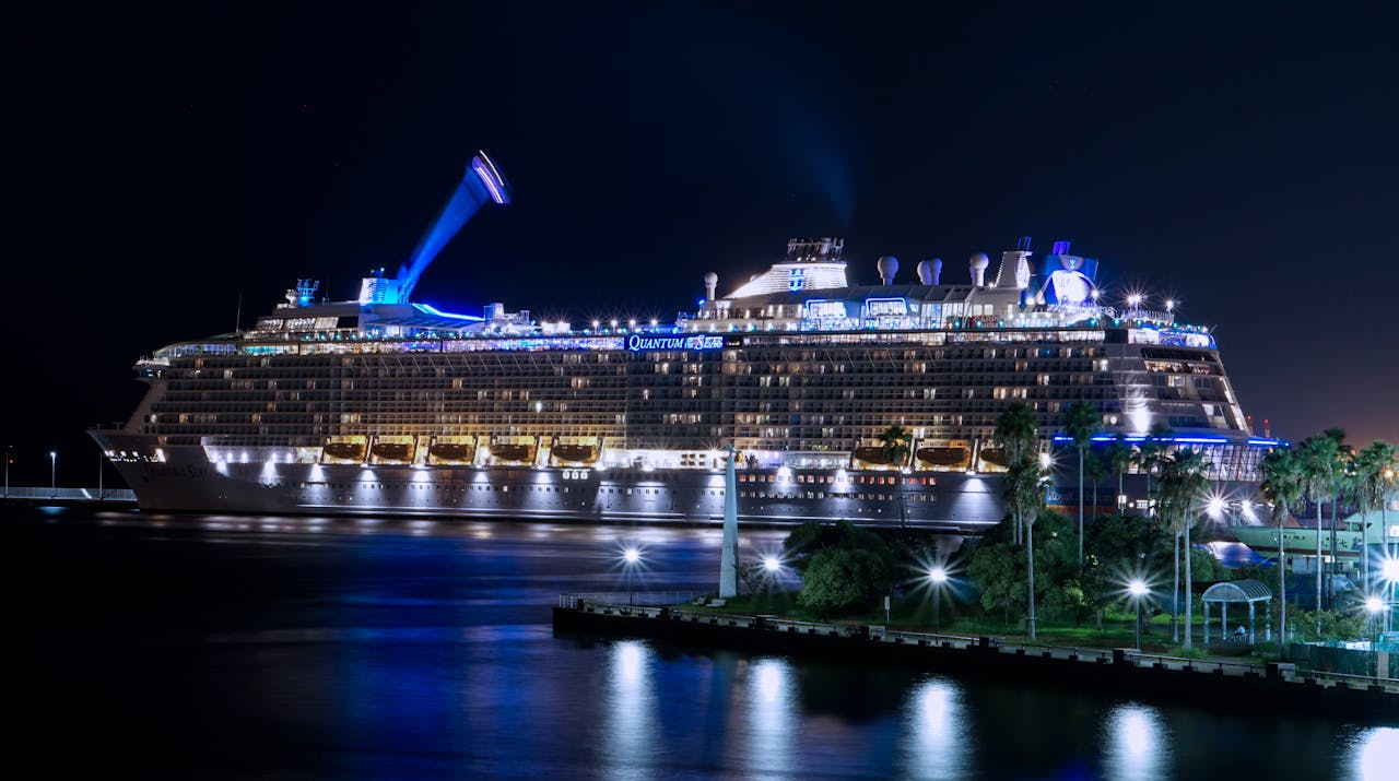 A stunning view of a cruise ship illuminated and docked at night in Fukuoka harbor.